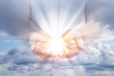 Image of Man with holy light in hands against sky, closeup