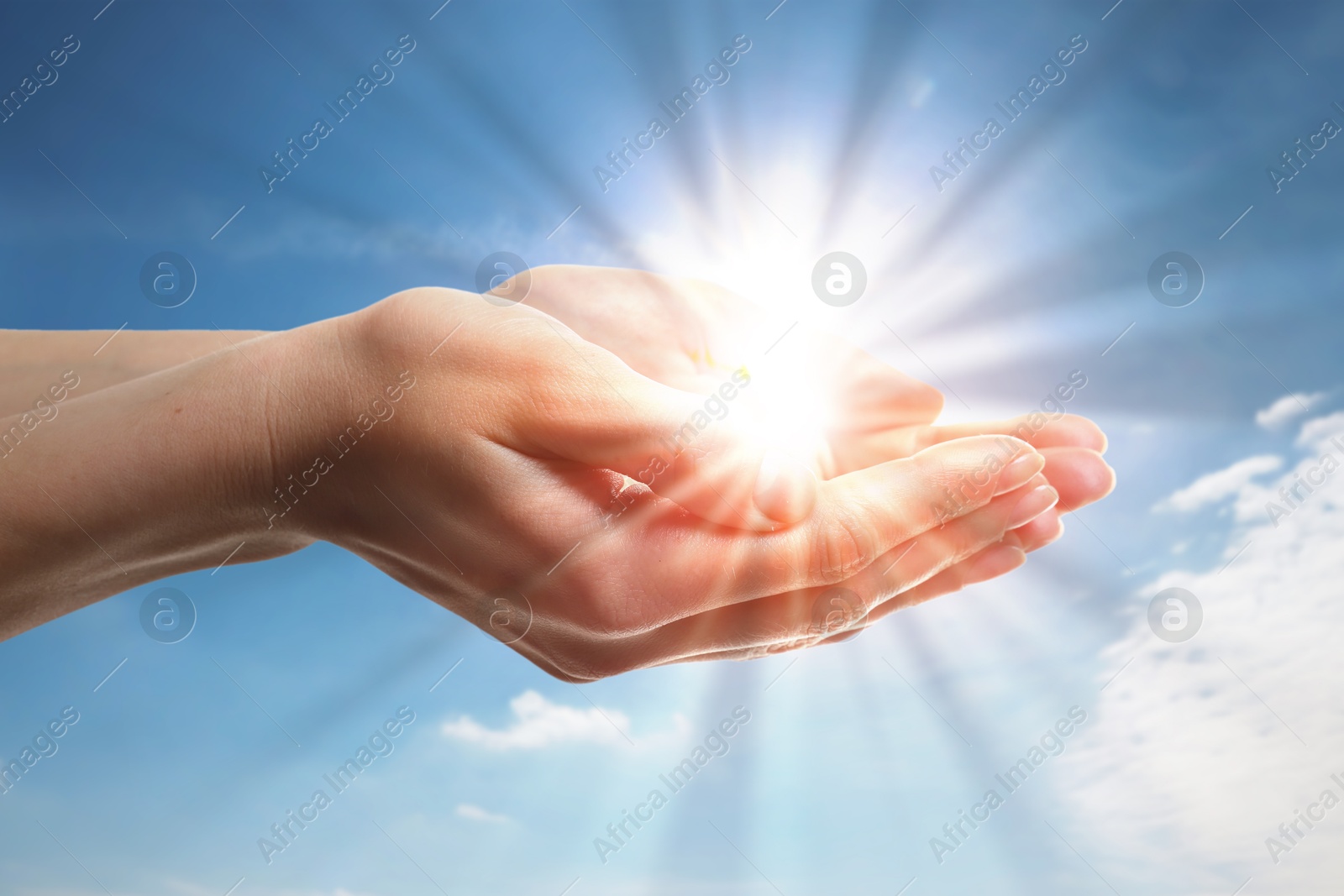 Image of Woman with holy light in hands against sky, closeup