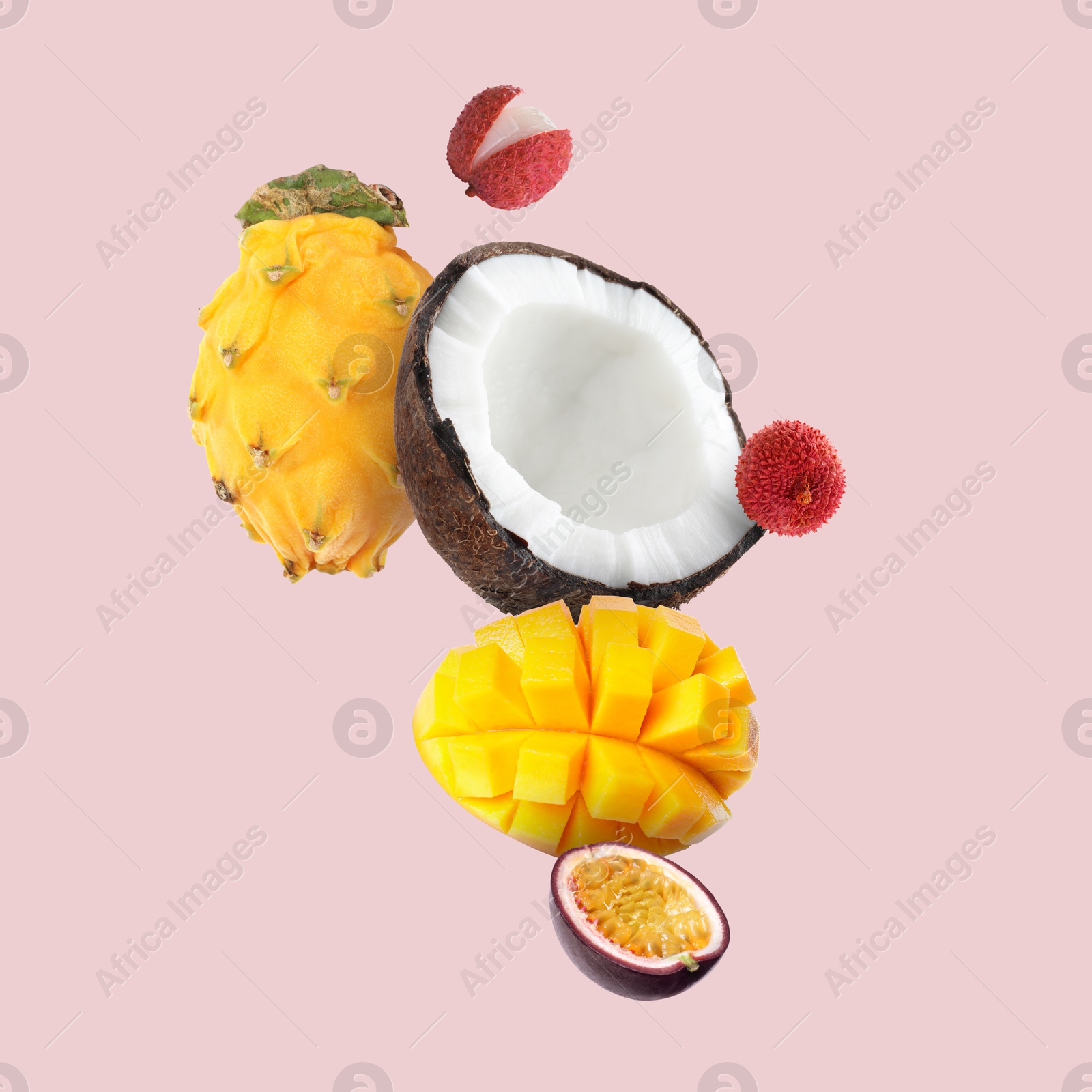 Image of Coconut, dragonfruit, mango, lychees and maracuja in air on pink background. Tropical fruits