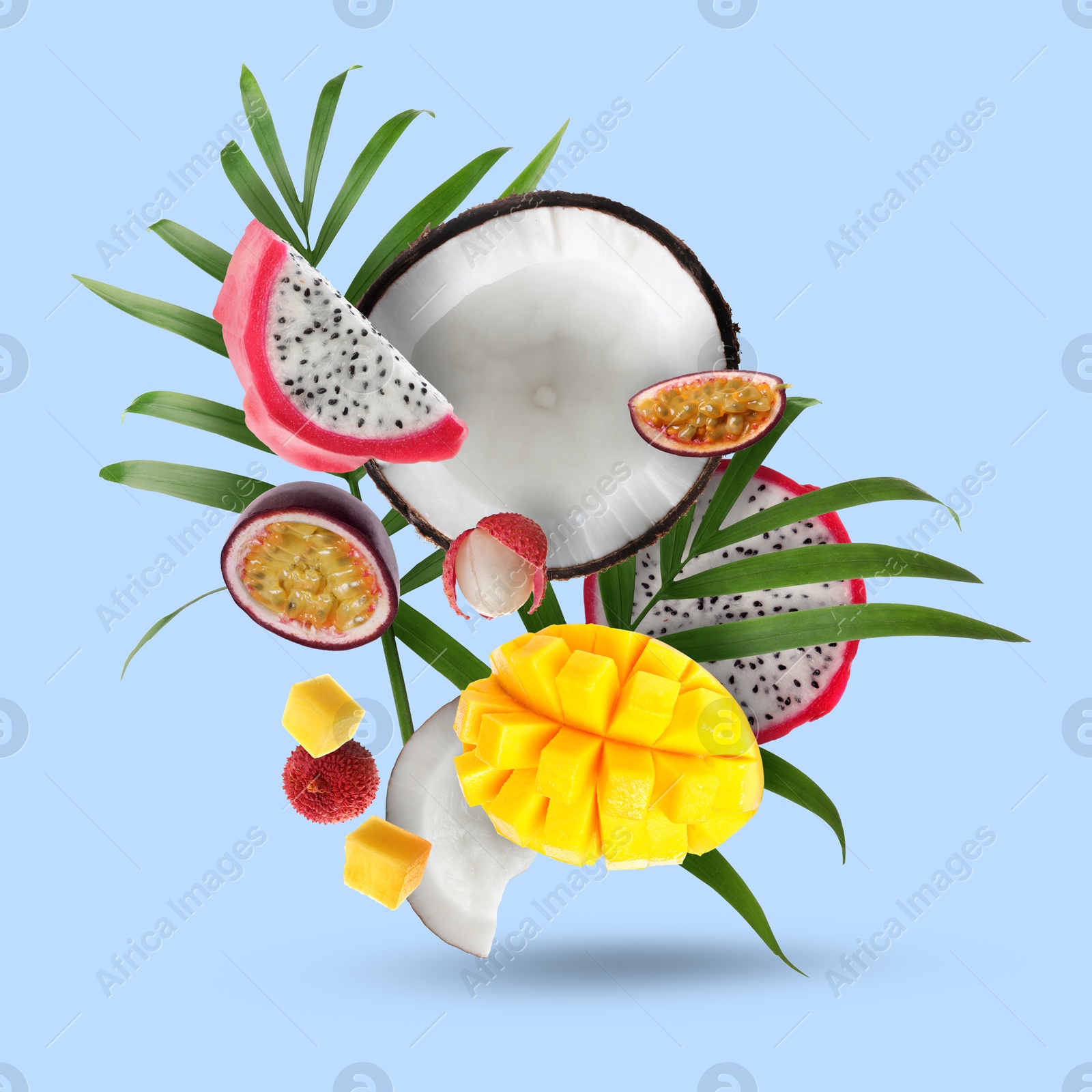 Image of Coconut, dragonfruit, mango, lychees and maracuja in air on light blue background. Tropical fruits