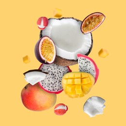 Image of Coconut, dragonfruit, mango, lychees and maracuja in air on golden background. Tropical fruits