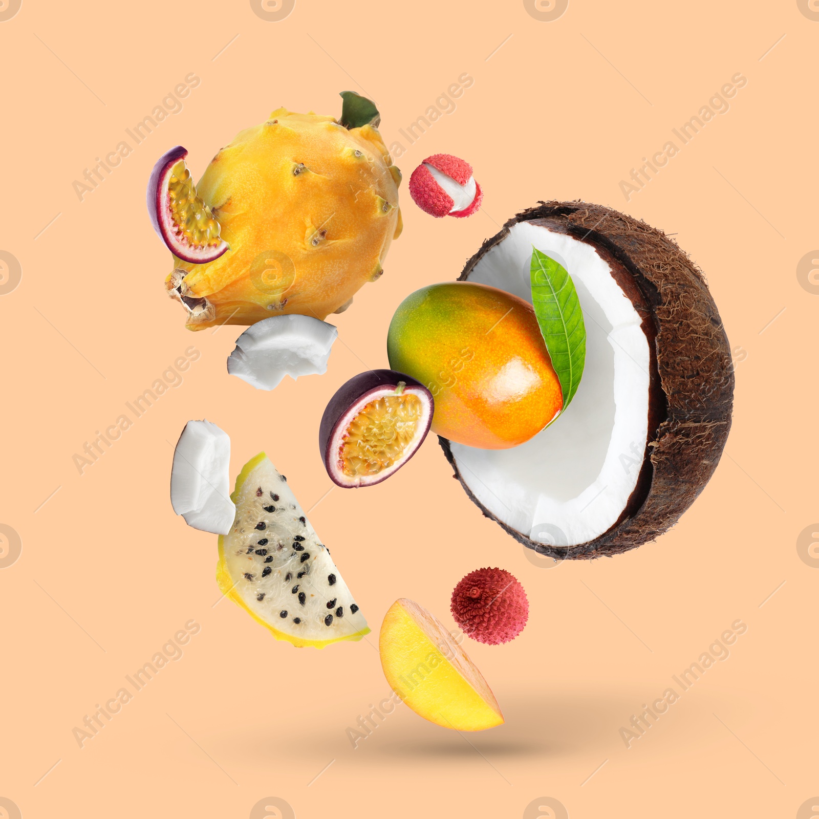 Image of Coconut, dragonfruit, mango, lychees and maracuja in air on dark beige background. Tropical fruits