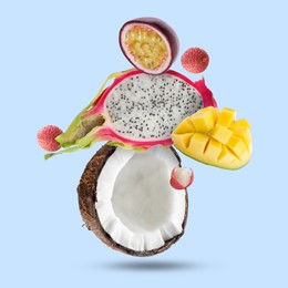 Image of Coconut, dragonfruit, mango, lychees and maracuja falling on light blue background. Tropical fruits