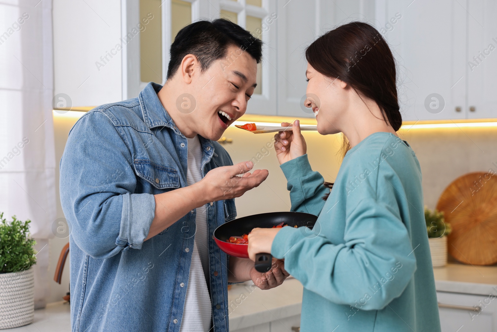 Photo of Happy lovely couple cooking together in kitchen