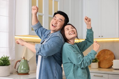 Photo of Happy lovely couple dancing together in kitchen