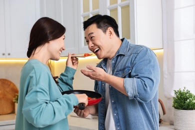 Photo of Happy lovely couple cooking together in kitchen