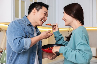 Photo of Happy lovely couple cooking together in kitchen