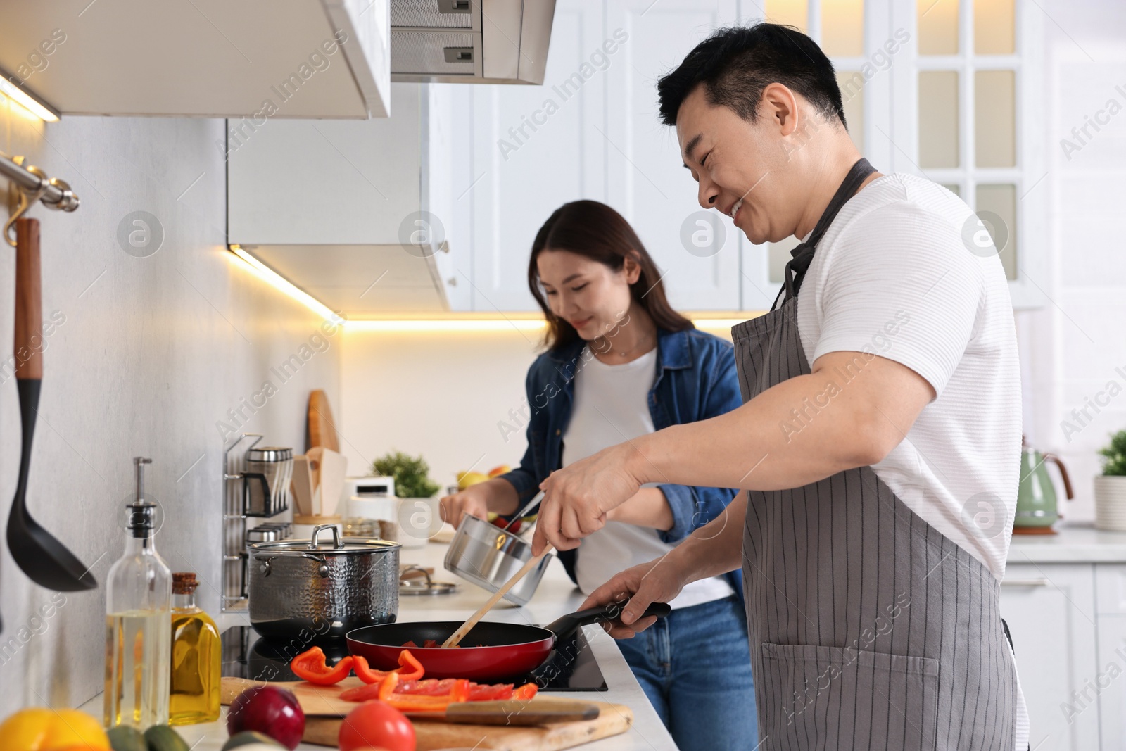 Photo of Happy lovely couple cooking together in kitchen