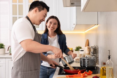 Photo of Happy lovely couple cooking together in kitchen