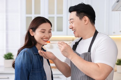 Photo of Happy lovely couple cooking together in kitchen