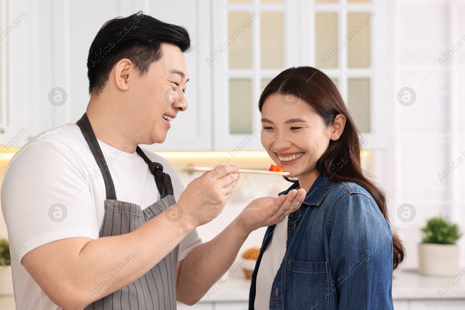 Photo of Happy lovely couple cooking together in kitchen