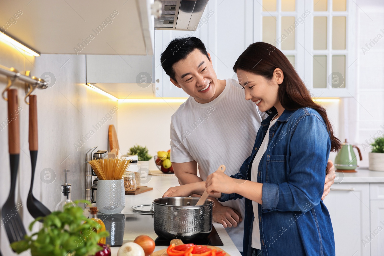 Photo of Happy lovely couple cooking together in kitchen