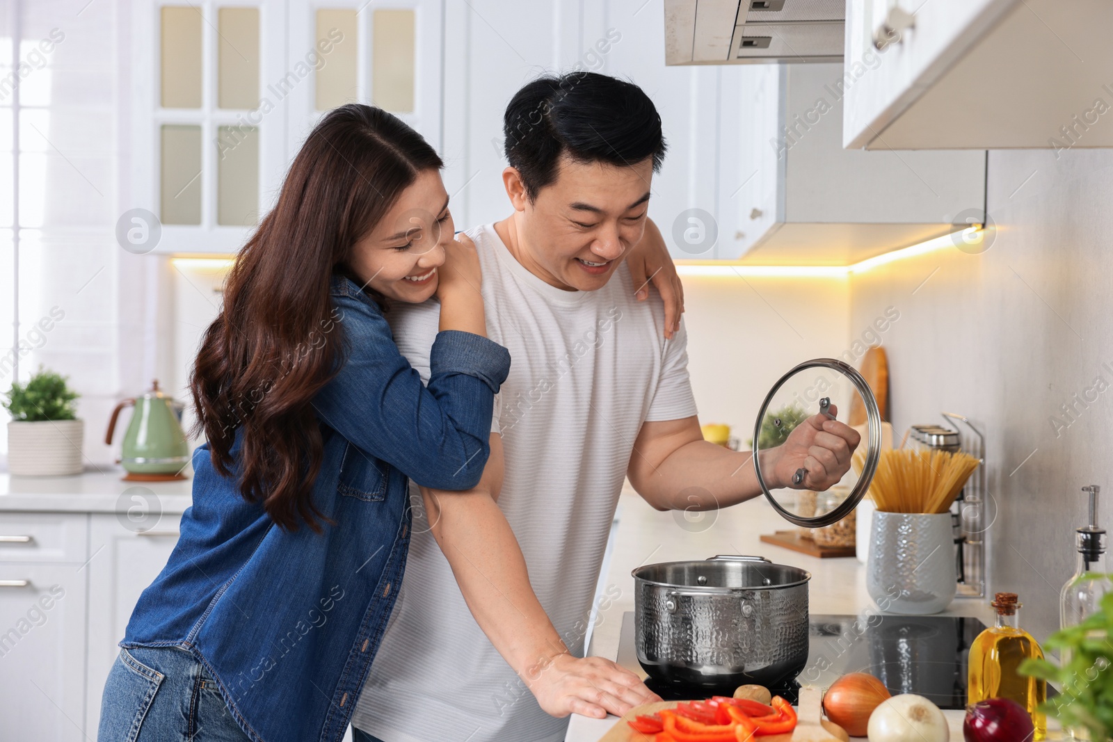 Photo of Happy lovely couple cooking together in kitchen