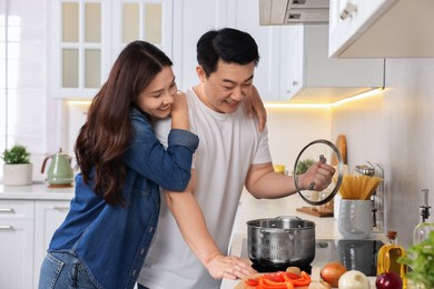 Happy lovely couple cooking together in kitchen