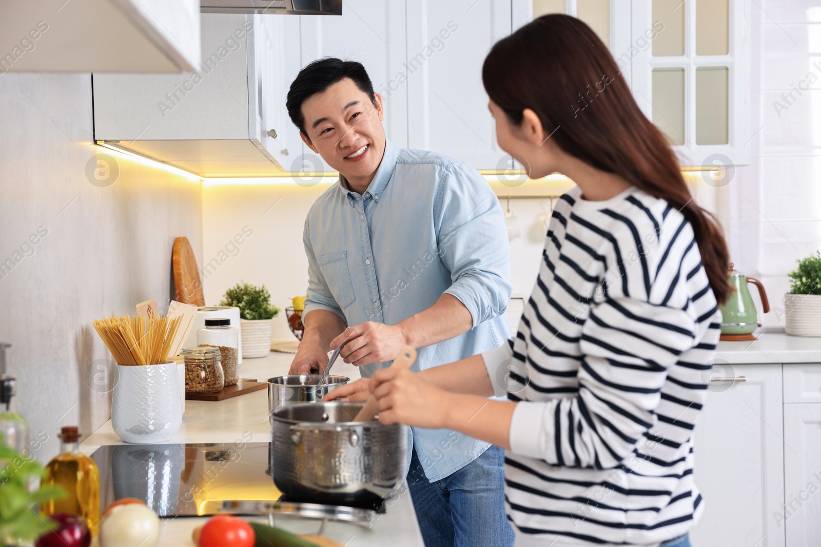 Photo of Happy lovely couple cooking together in kitchen