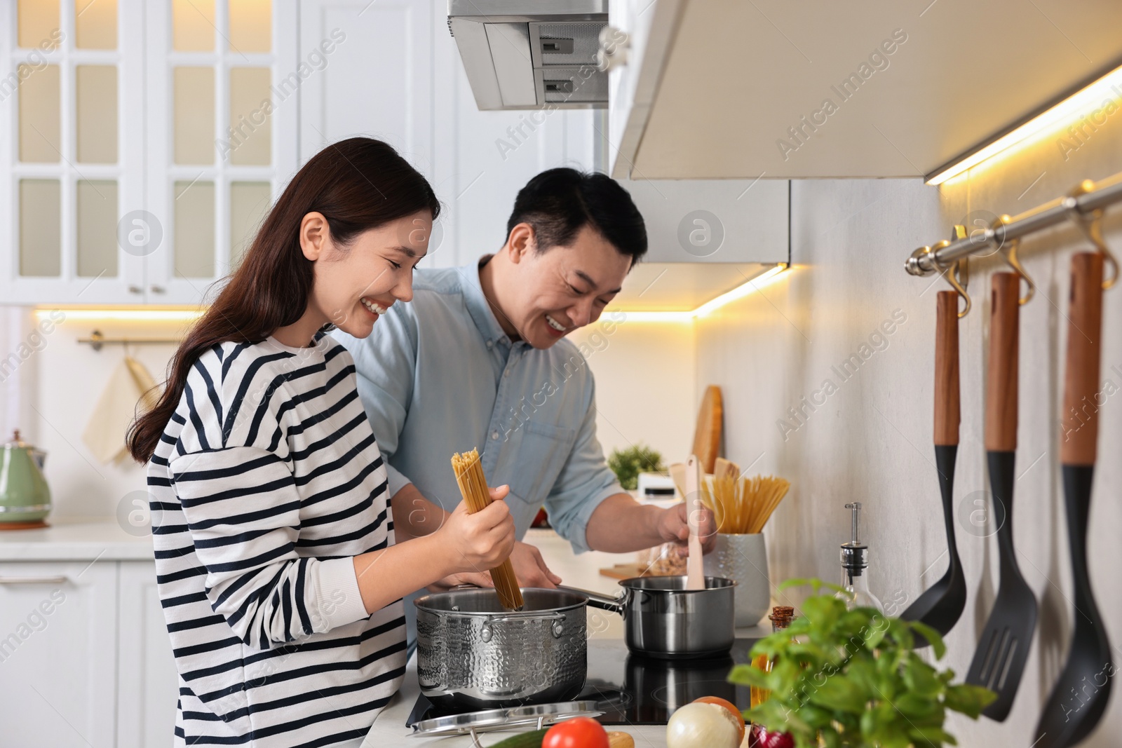 Photo of Happy lovely couple cooking together in kitchen