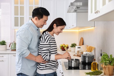 Photo of Happy lovely couple cooking together in kitchen