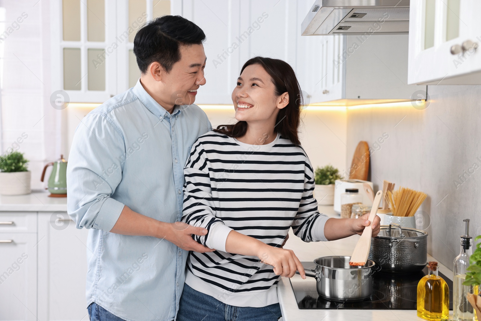 Photo of Happy lovely couple cooking together in kitchen