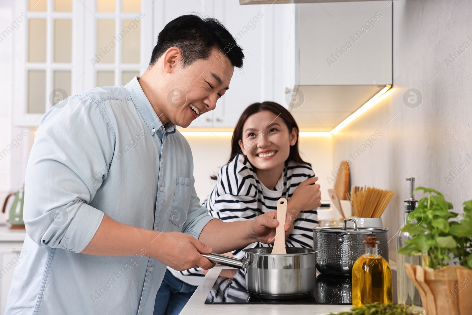 Photo of Happy lovely couple cooking together in kitchen