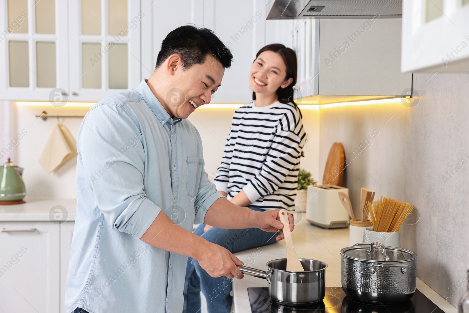 Photo of Happy lovely couple cooking together in kitchen