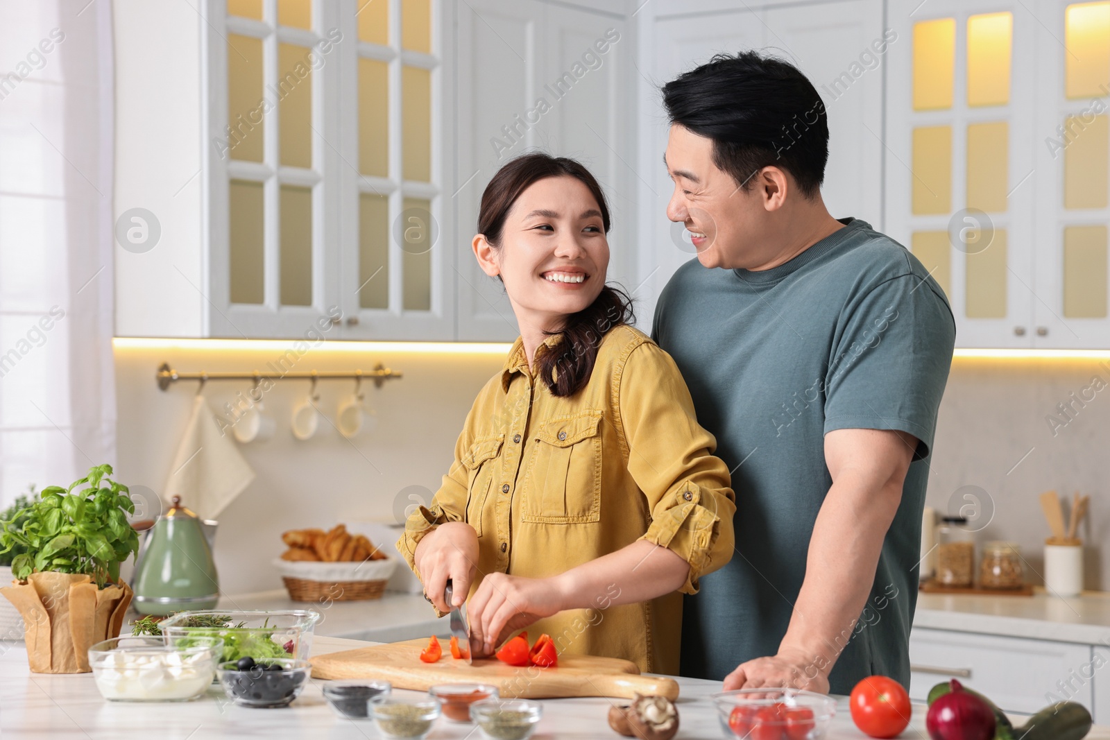 Photo of Happy lovely couple cooking together in kitchen