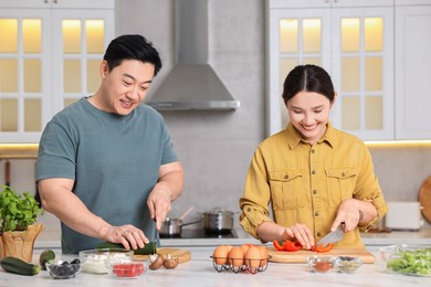 Photo of Happy lovely couple cooking together in kitchen