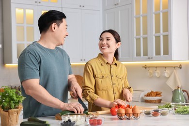 Photo of Happy lovely couple cooking together in kitchen