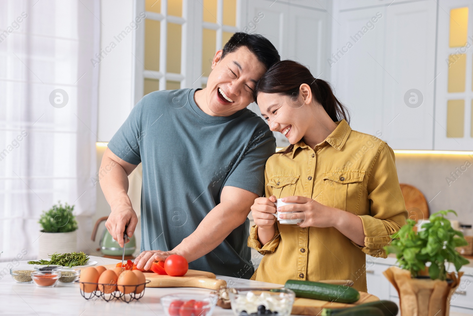 Photo of Happy lovely couple cooking together in kitchen