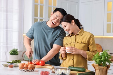 Happy lovely couple cooking together in kitchen