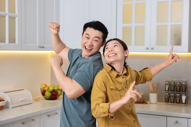 Happy lovely couple dancing together in kitchen