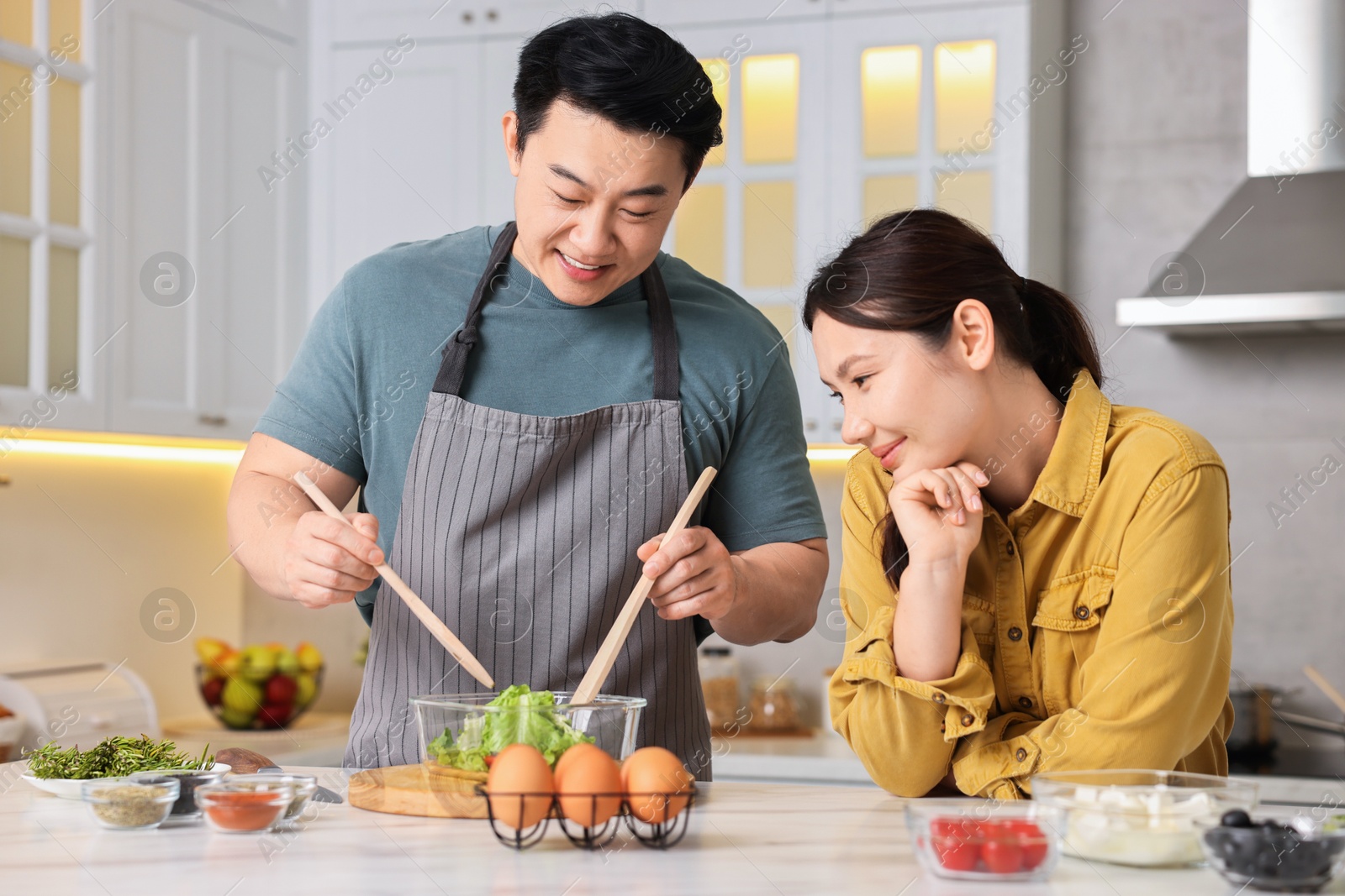 Photo of Happy lovely couple cooking together in kitchen