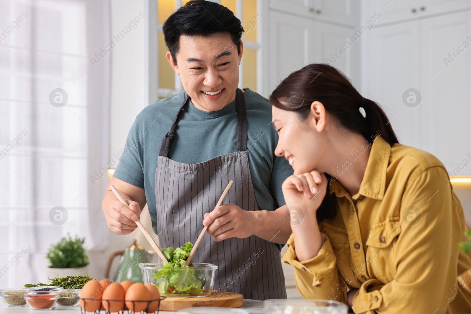 Photo of Happy lovely couple cooking together in kitchen