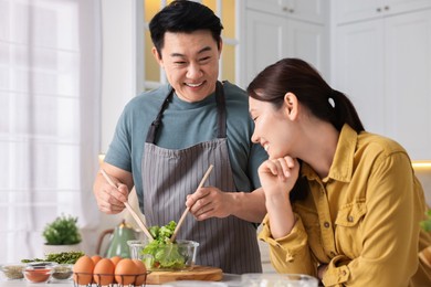 Happy lovely couple cooking together in kitchen