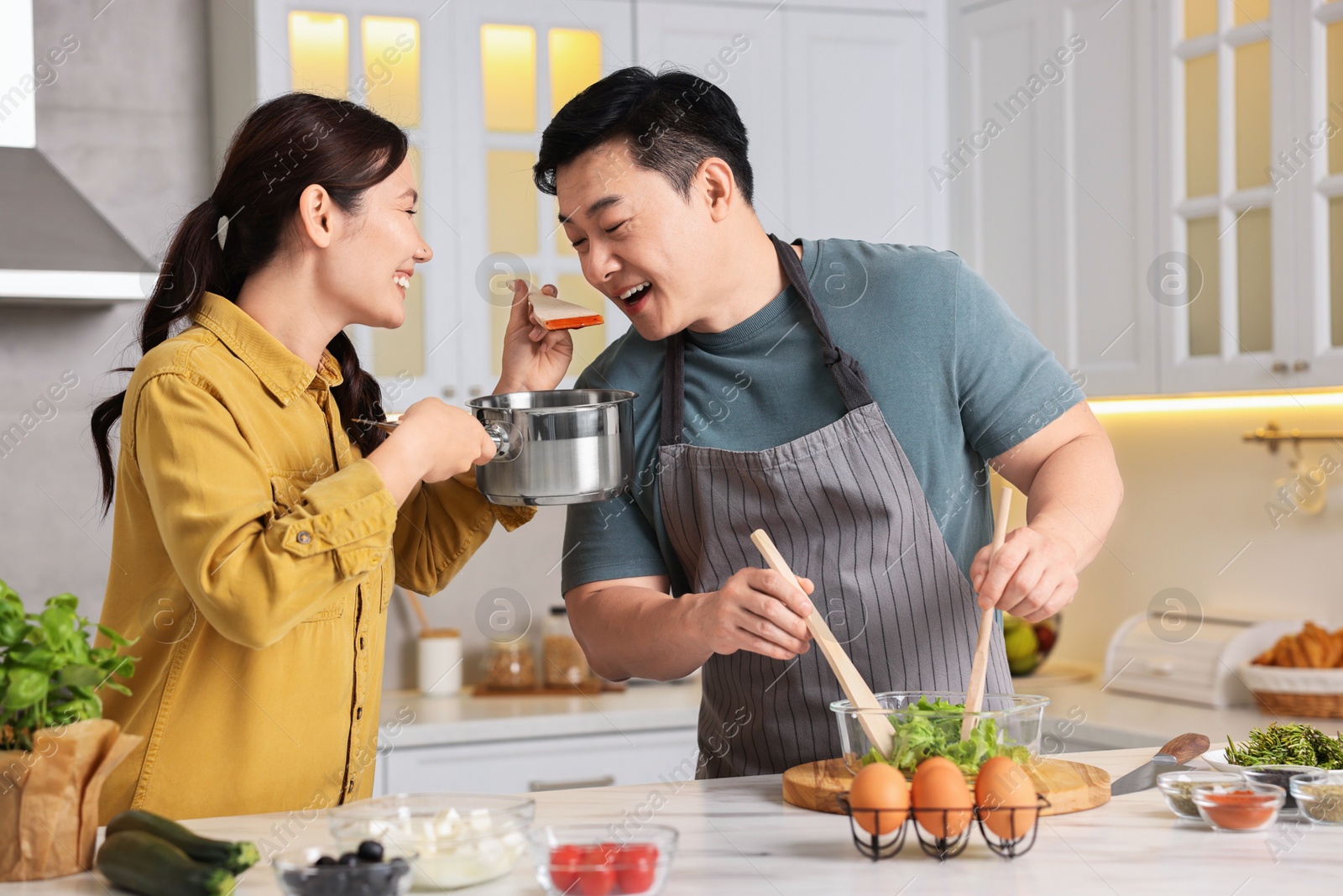 Photo of Happy lovely couple cooking together in kitchen