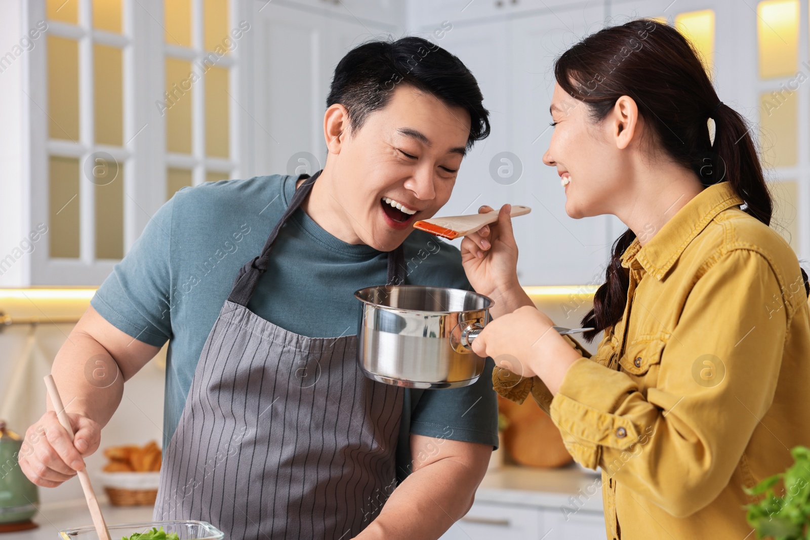 Photo of Happy lovely couple cooking together in kitchen