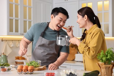 Photo of Happy lovely couple cooking together in kitchen