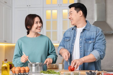 Happy lovely couple cooking together in kitchen