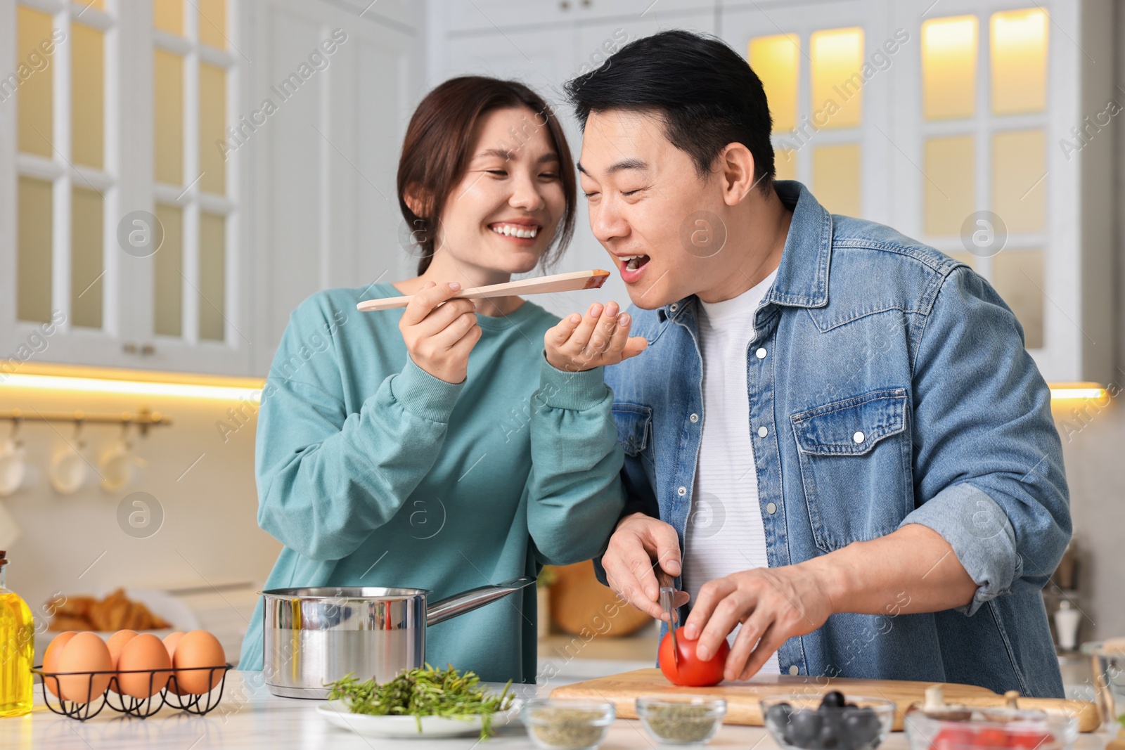 Photo of Happy lovely couple cooking together in kitchen