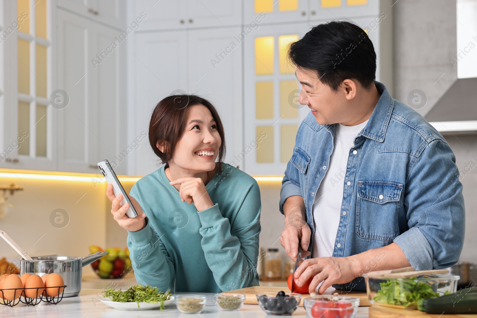 Photo of Happy lovely couple cooking together in kitchen