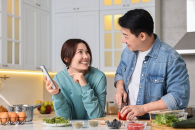 Happy lovely couple cooking together in kitchen