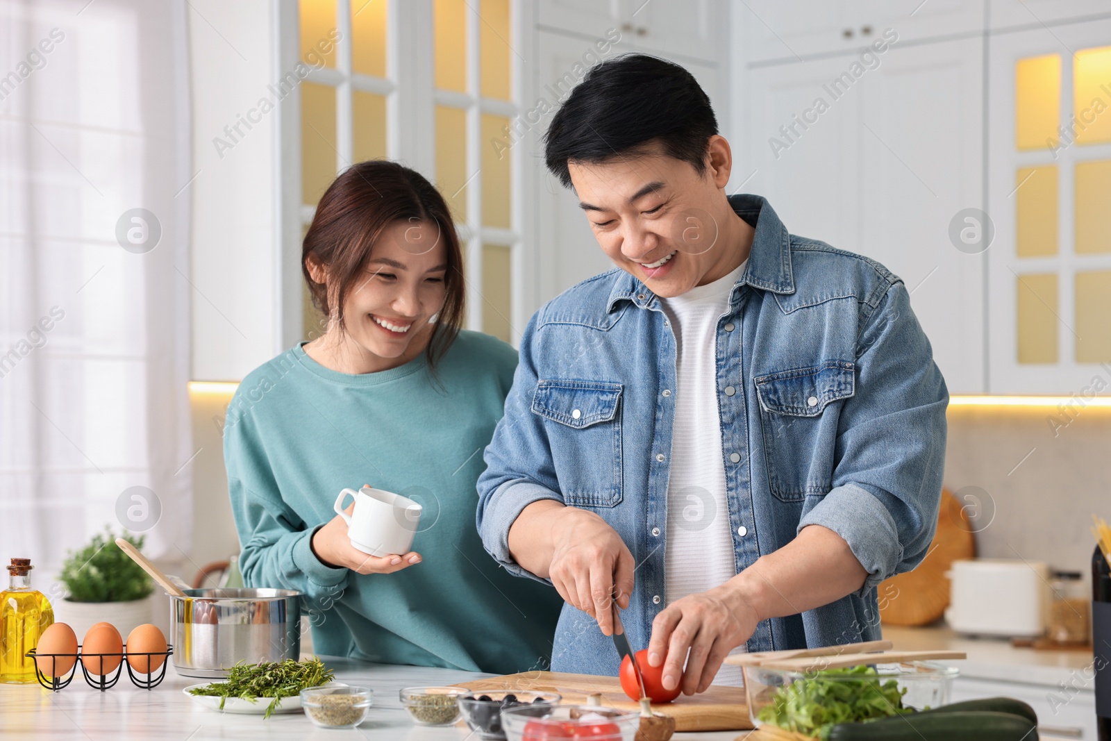 Photo of Happy lovely couple cooking together in kitchen