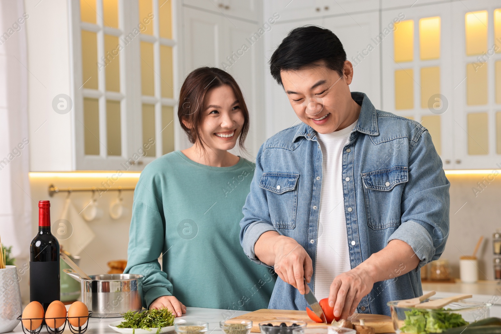 Photo of Happy lovely couple cooking together in kitchen