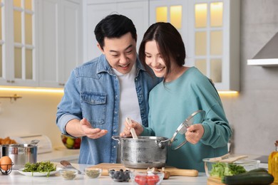 Photo of Happy lovely couple cooking together in kitchen