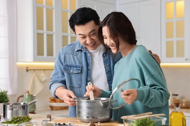 Photo of Happy lovely couple cooking together in kitchen