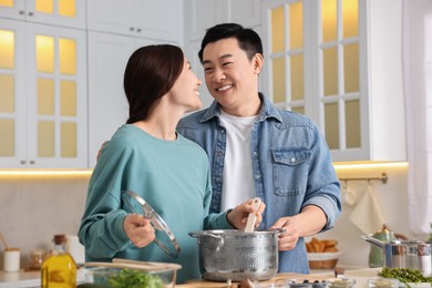 Photo of Happy lovely couple cooking together in kitchen