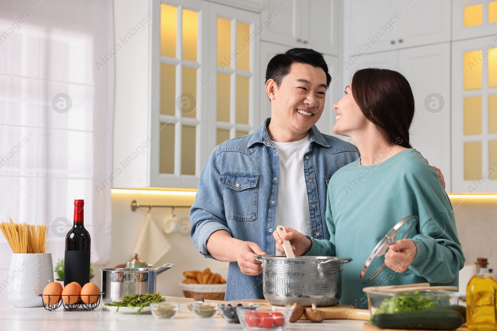 Photo of Happy lovely couple cooking together in kitchen