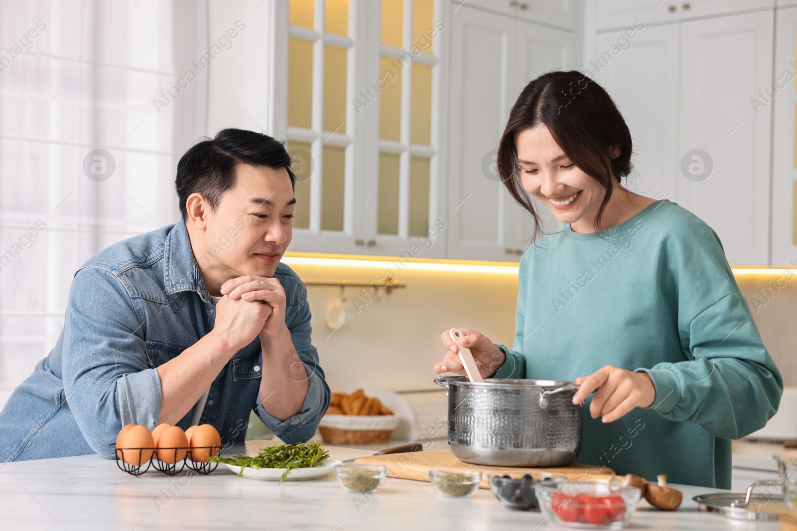 Photo of Happy lovely couple cooking together in kitchen