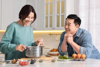 Photo of Happy lovely couple cooking together in kitchen