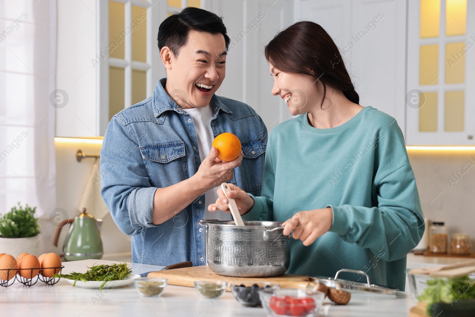 Photo of Happy lovely couple cooking together in kitchen