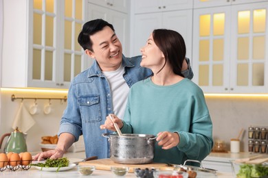 Photo of Happy lovely couple cooking together in kitchen